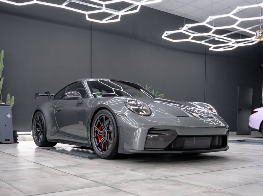 Seitliche Frontansicht eines Porsche 911 GT3 in Grau mit Fokus auf die roten Bremssättel.